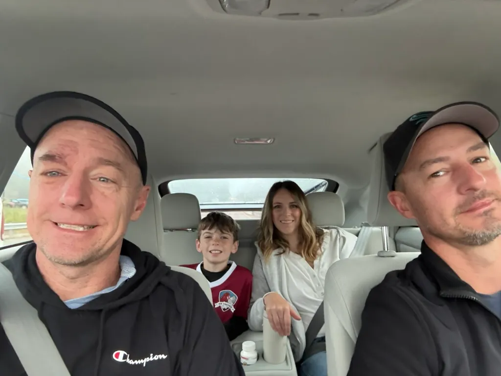 A car selfie on the way to Lucas's soccer game, with Lucas in his jersey and his mom in the back seat.